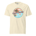 An ivory-colored t-shirt with an illustration of a beach landscape with waves and palm trees with the caption, "I burn easily".