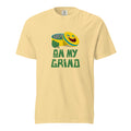 Yellow t-shirt with an illustration of a marijuana grinder with a happy face on the lid with the caption "On My Grind".